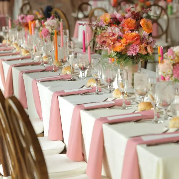 long tables with pink napkins and flowers