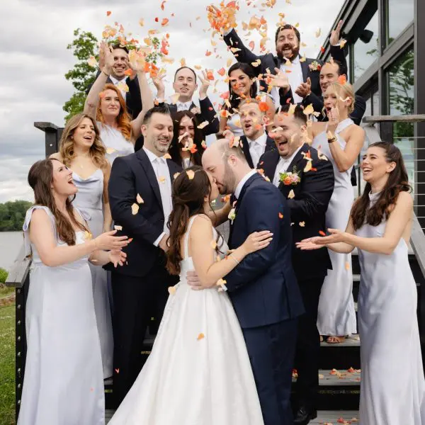 Wedding party celebrates as bride and groom kiss
