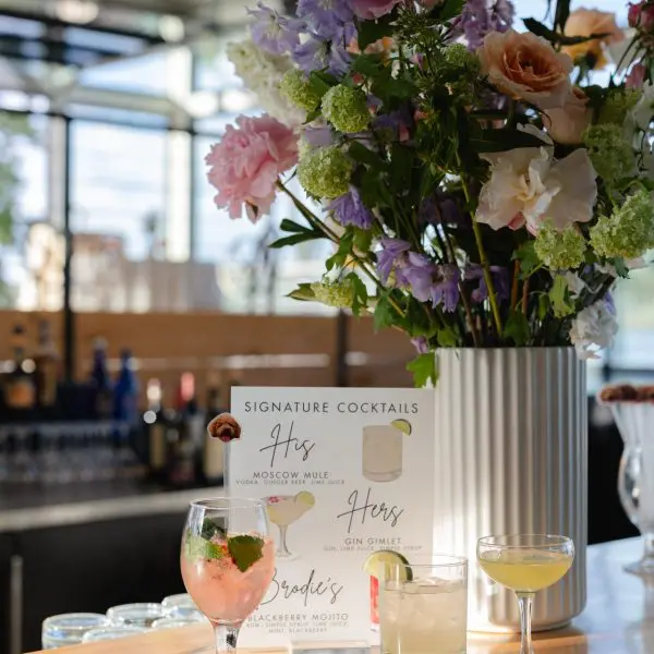 Cocktail menu and flowers on table