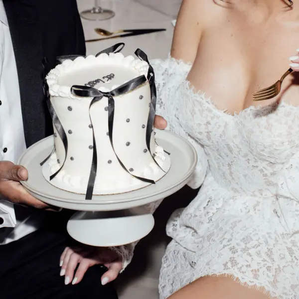 Wedding cake being held by bride and groom